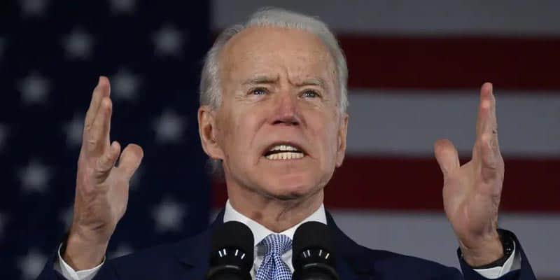 Joe Biden speaking with determination and hands raised