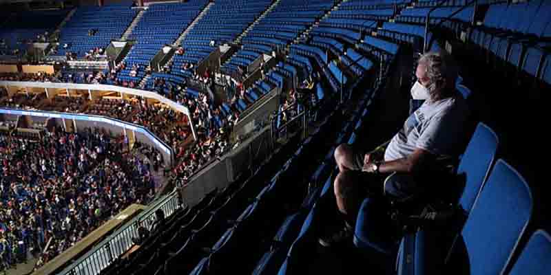 a man sitting alone with a mask on in the upper deck of Trump's rally in Tulsa