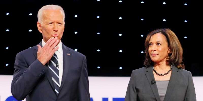 Joe Biden blowing a kiss to the audience with Kamala Harris standing to the right