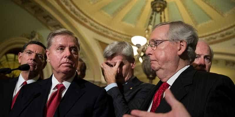 Lindsey Graham standing to the left of Mitch McConnell facing the press