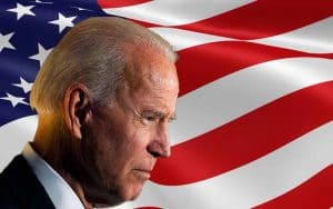 Joe Biden in profile in front of an American flag