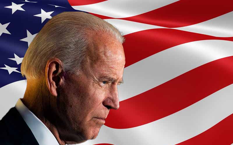 Joe Biden in profile in front of an American flag