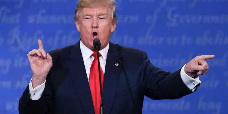 donald trump pointing while standing at microphone